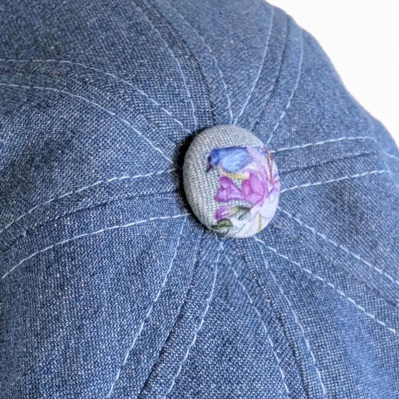 Poorboy Fashion Cap in washed blue denim, floral with hummingbird accents, flattering visor, baggy fit