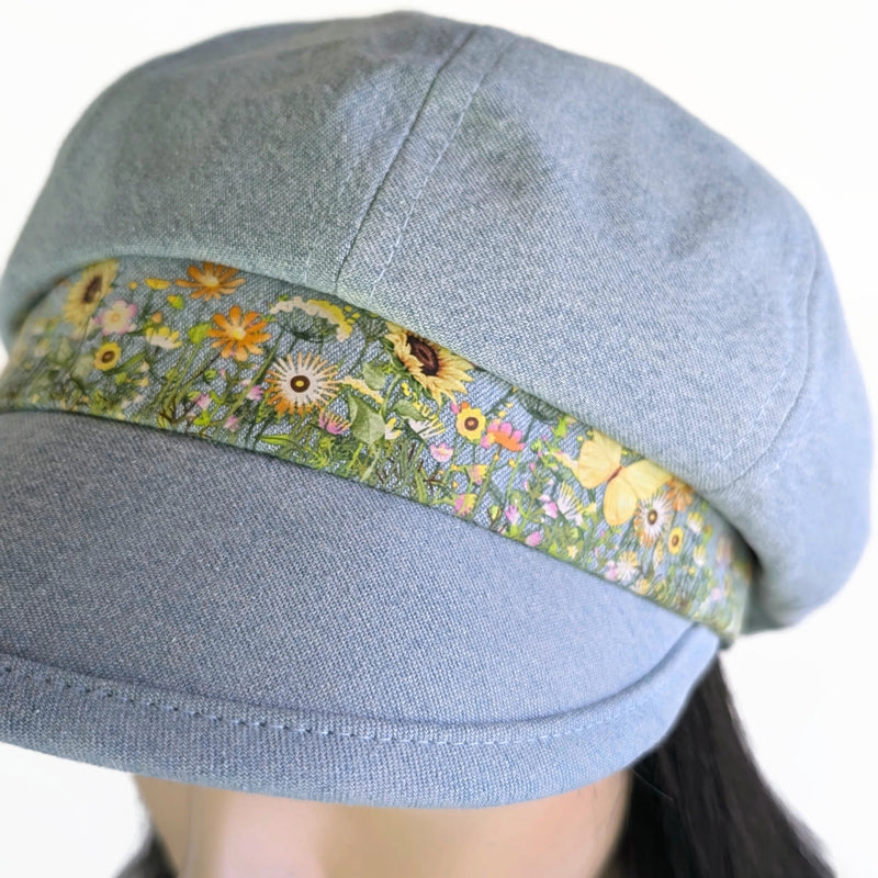 Poorboy Fashion Cap in bleached blue denim, yellow sunflower butterfly accents, flattering visor, baggy fit